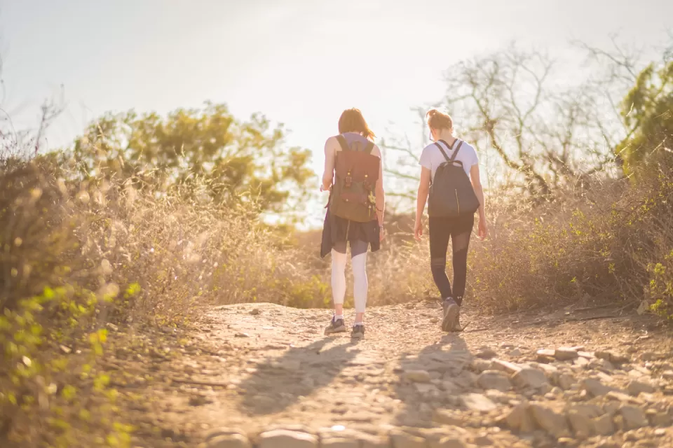 Two young women hiking at golden hour.
